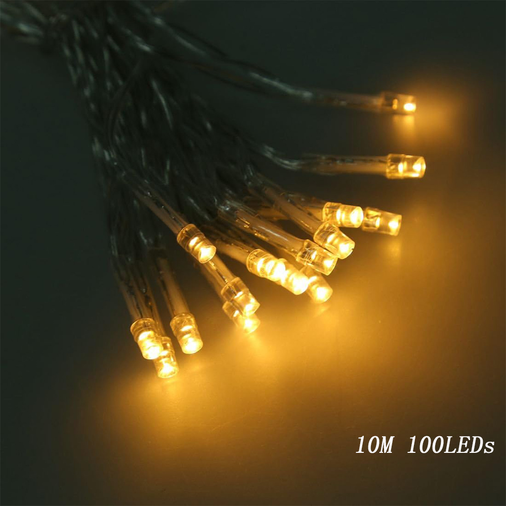Warm white fairy lights coiled on a wooden surface